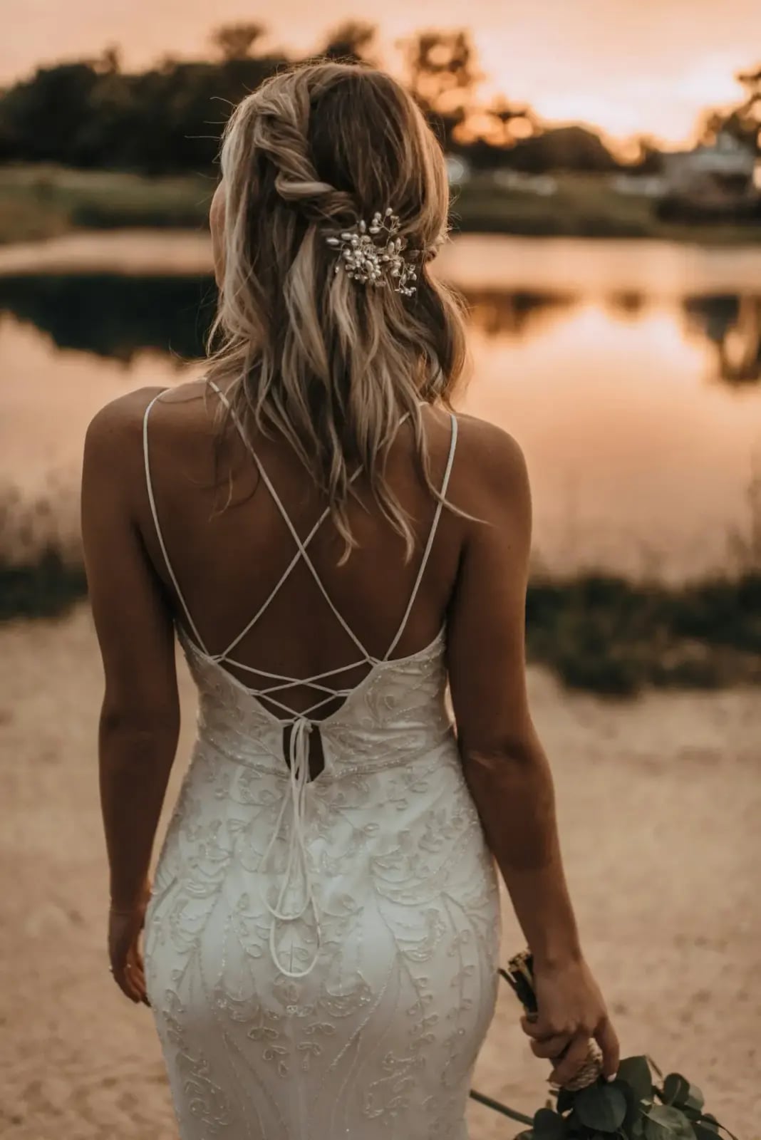 Braut im angepassten Brautkleid, Rückenansicht im Sonnenuntergang
